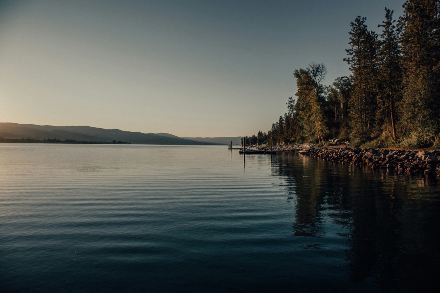 Still lake water at dusk reflecting soft evening light